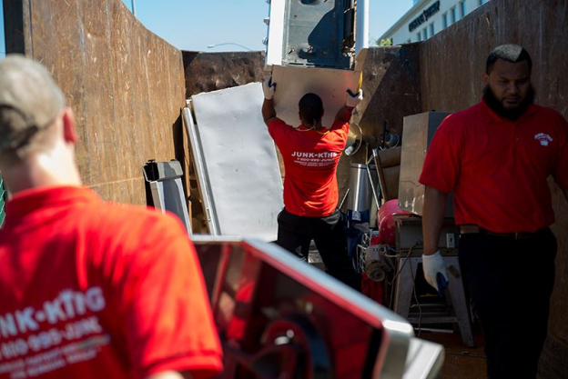 Junk King Servicemen loading junk and e-waste onto a Junk King Truck